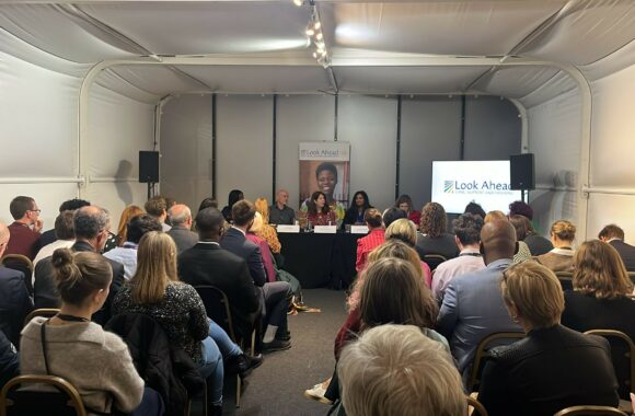 A busy conference room with key speakers and guests.